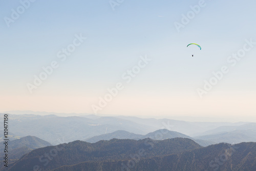 Paraglider flying over mountains