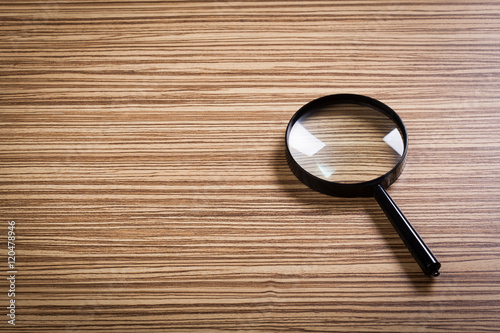magnifying glass on the wooden background