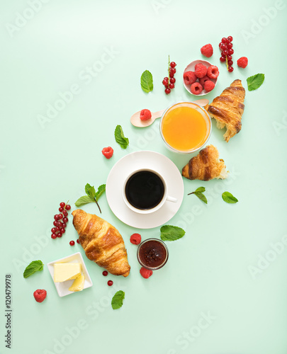 breakfast time with croissants and coffee on green table