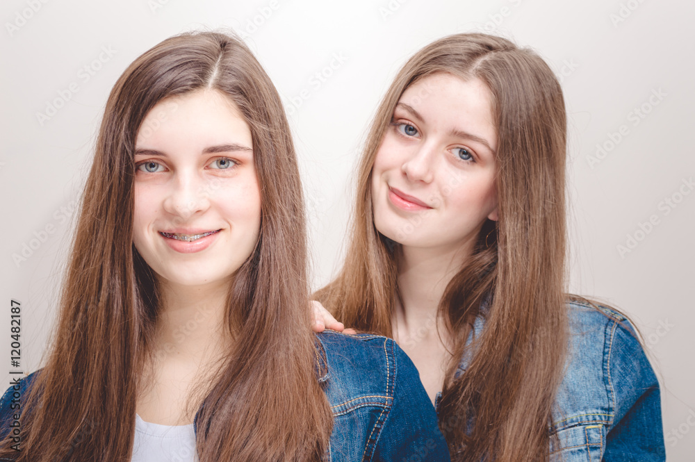 fashion photo of two beautiful young women with long dark hair and bright makeup wears casual clothes,posing in studio fashion photo of two beautiful young women with long dark hair and bright makeup wears casual clothes,posing in studio