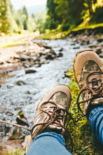 Hiking shoes on hiker walking outdoors. Men on trekking in nature. Close up of hiking boots.