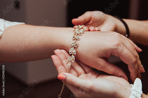 Bridal preparation, bride putting on jewelry, focus on bracelet