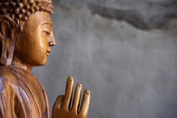 Rollo Buddha Holzstatue des Buddha im Halbdunkel  © SianStock