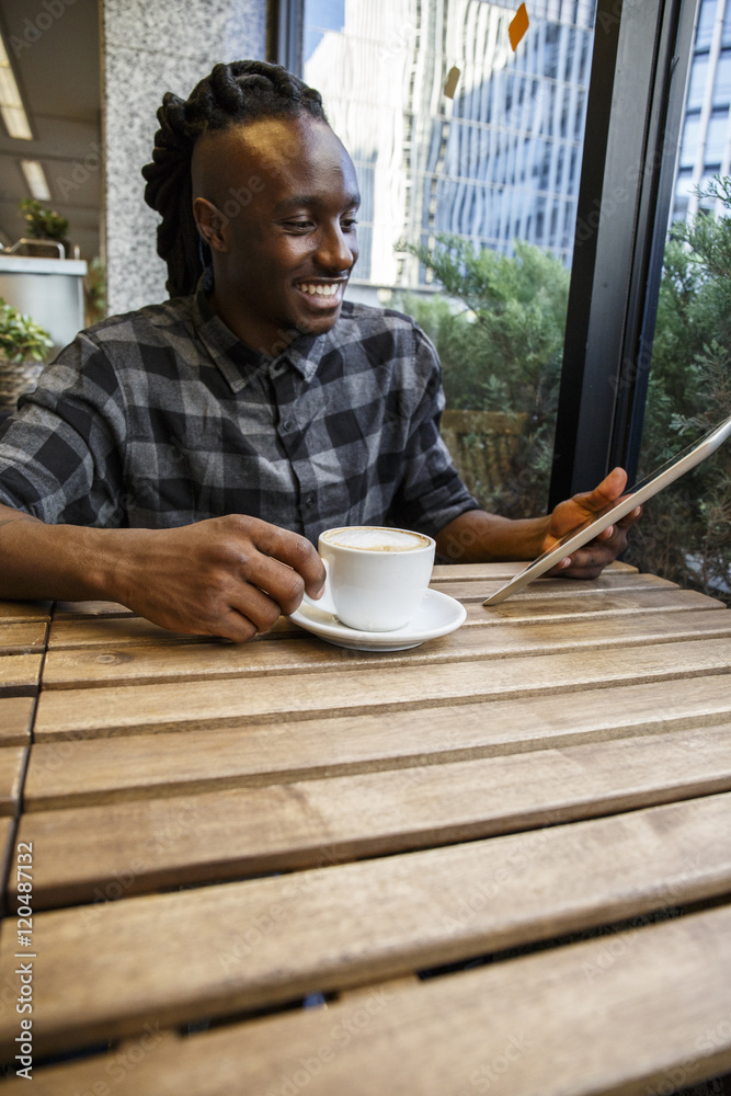Young man sitting in cafe, using digital tablet Young man sitting in cafe, using digital tablet