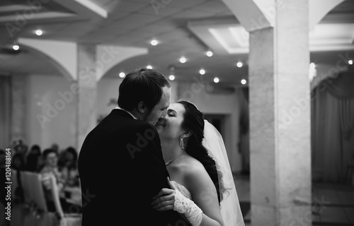 groom kissing her bride in restaurant