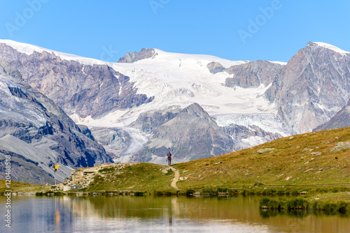 Fototapeta Naklejka Na Ścianę i Meble -  Hiker at Stellisee - beautiful lake with reflection of Matterhorn - Zermatt, Switzerland