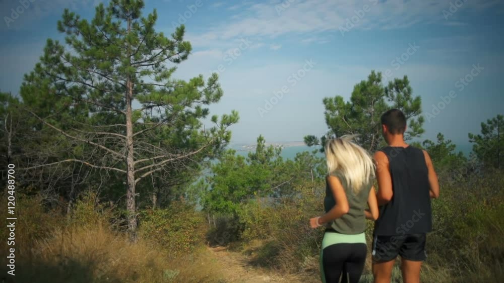 Sportive couple jogging down hill sea background Slow motion