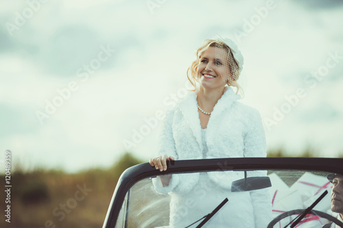Gorgeous stylish  bride posing in retro car in white dress © andriychuk