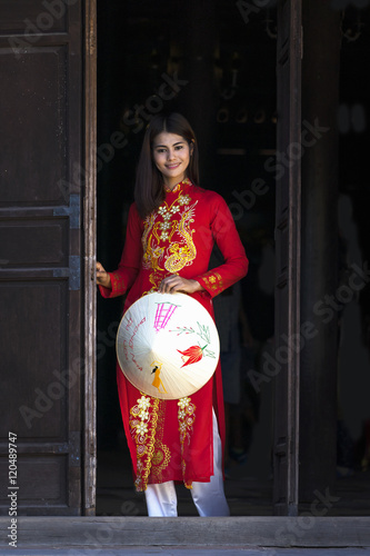 Beautiful woman with Vietnam culture traditional dress, Ao dai is famous traditional costume , vintage style, Hoi an Vietnam, holding hat photo