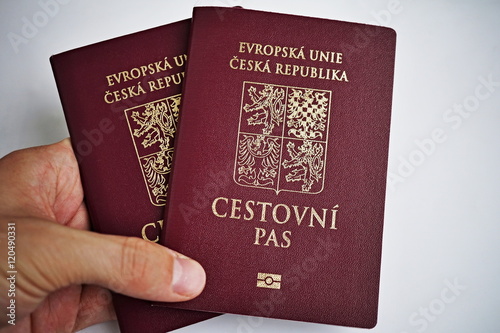 Male hand holding red Czech passport with a state symbols (lions and eagles) and captions Czech Republic and European Union in Czech language