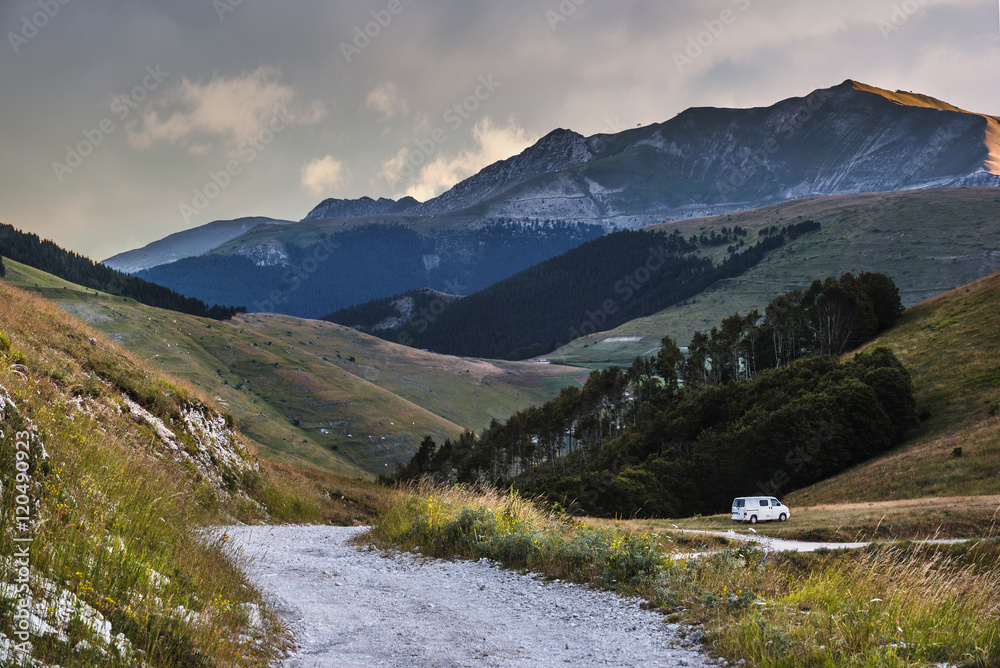 Car on gravel surface road in the mountains