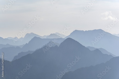 Silhouette of blue mountains in the fog. View of Moldoveanu peak, the highest peak from Romanian Carpathian Mountains range. Seamless background. photo