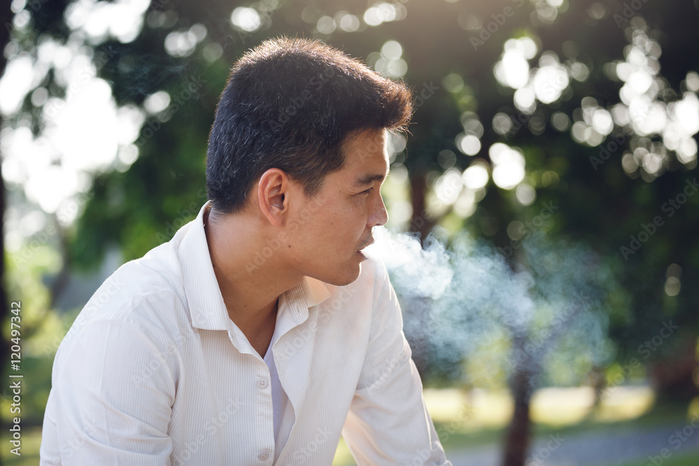 Man smoking and blurred tree Background Man smoking and blurred tree Background