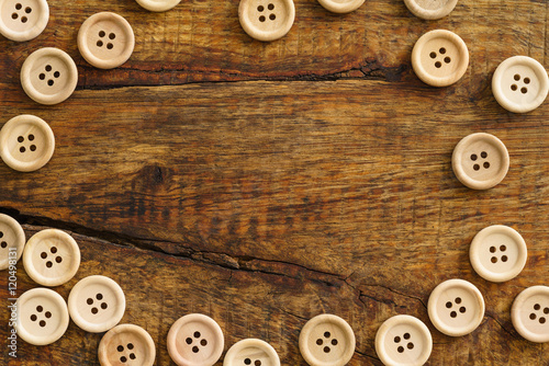 Collection of wooden buttons on wooden background with copyspace