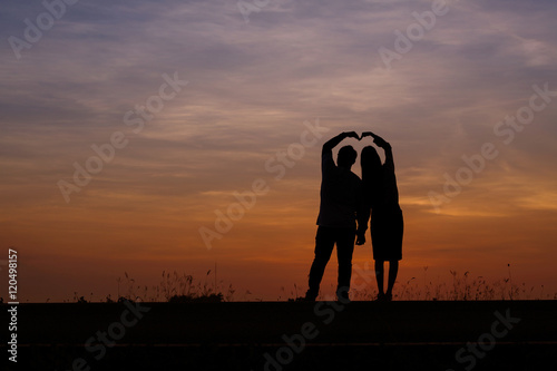 Silhouette man and woman with beautiful the sky at sunset..Backg