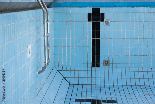 Empty swimming pool with metal ladder