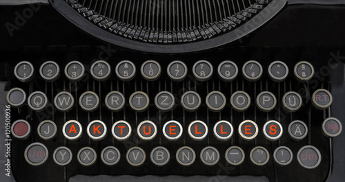 Wort Aktuelles auf der Tastatur einer antiken Schreibmaschine mit Spotlight