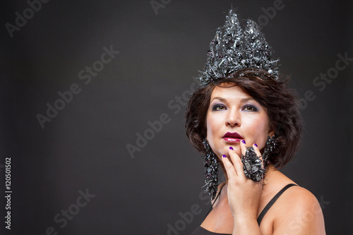 Портрет шикарной женщины с роскошной короной, серьгами и кольцом.