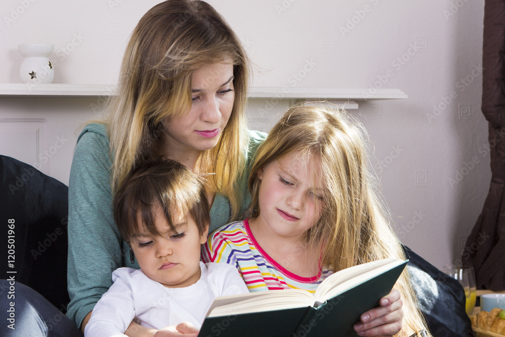 Tired mother reading book to kids Tired mother reading book to kids