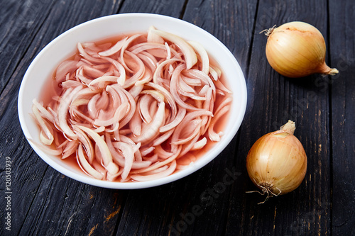 Pickled onion on wooden background photo