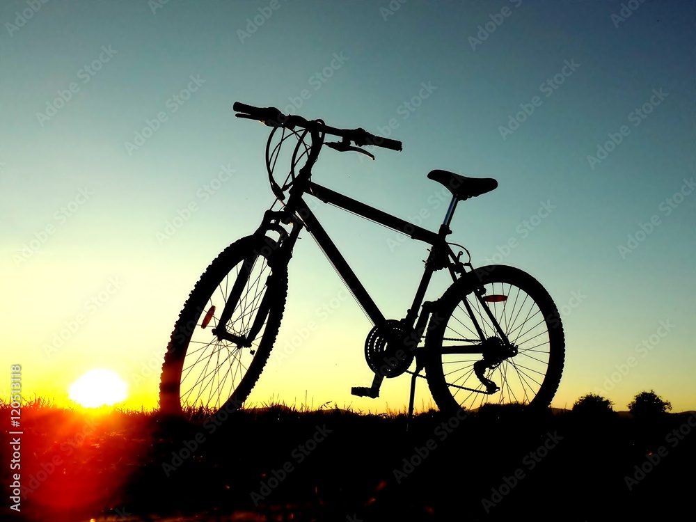 Fototapeta premium Mountain bike on hill during sunset