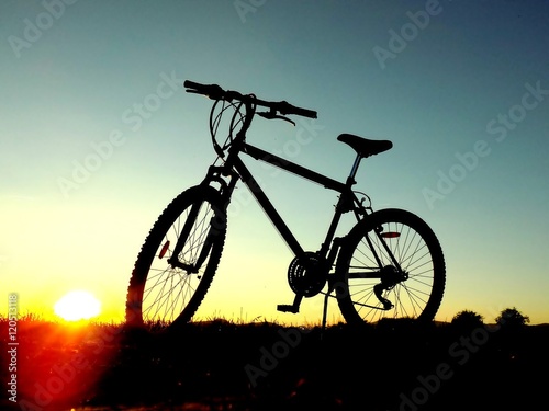 Mountain bike on hill during sunset