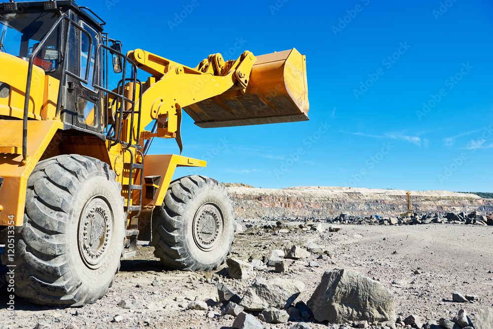 Fototapeta premium wheel loader excavator at granite or iron ore opencast mine