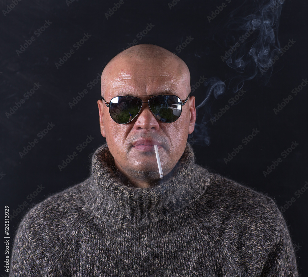 studio portrait of a bald man with glasses and a cigarette studio portrait of a bald man with glasses and a cigarette