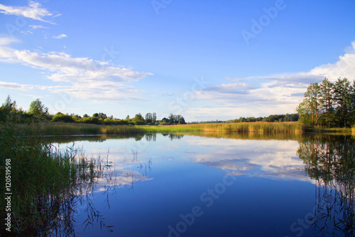 Fototapeta Naklejka Na Ścianę i Meble -  Fishing rod in hand on a background of lake