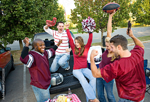 Tailgating: Group Of Friends Cheering While Listening To Footbal photo
