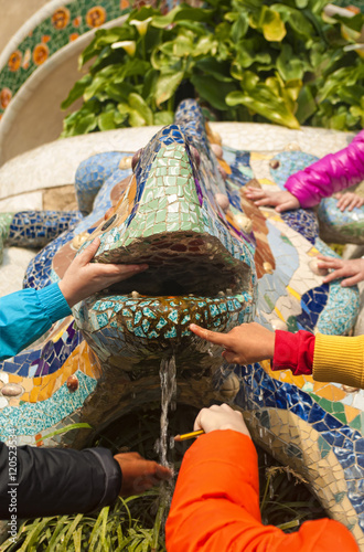 children's hands touching famous statue