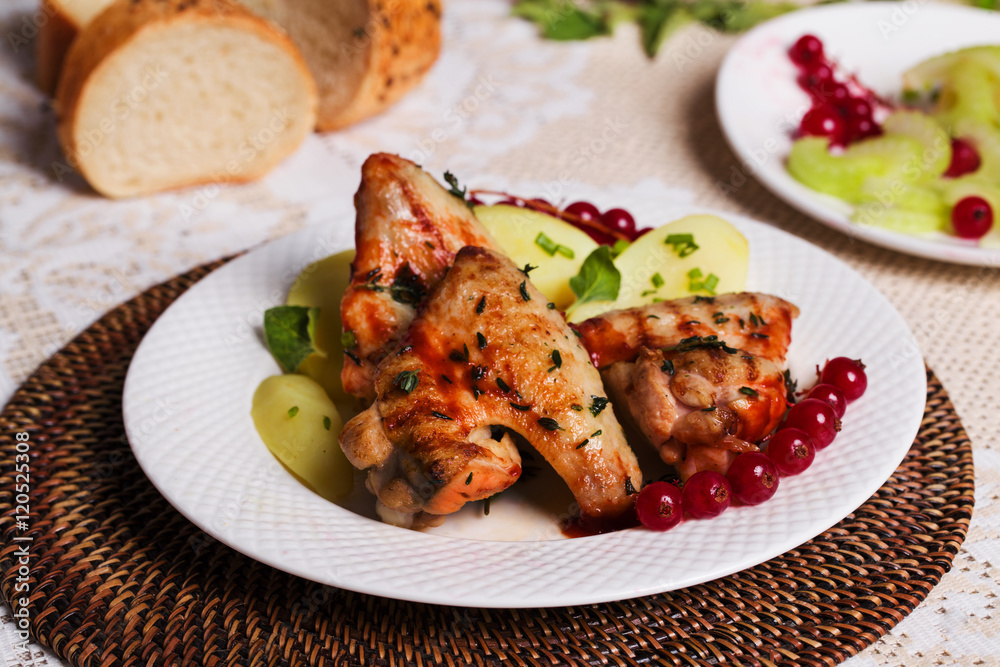 chicken wings with potatoes and cranberries on the plate, still life in the restaurant chicken wings with potatoes and cranberries on the plate, still life in the restaurant