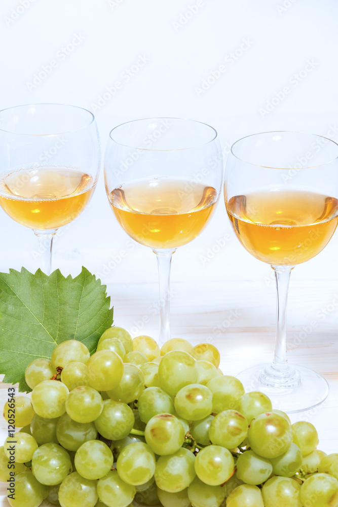 Bunch of ripe muscat grapes and wine glasses with white wine Bunch of ripe muscat grapes and wine glasses with white wine