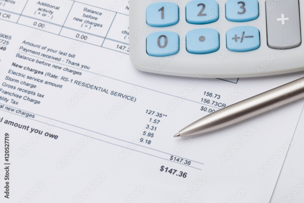 Studio shot of calculator and pen over some receipt under it - focus on pen Studio shot of calculator and pen over some receipt under it - focus on pen