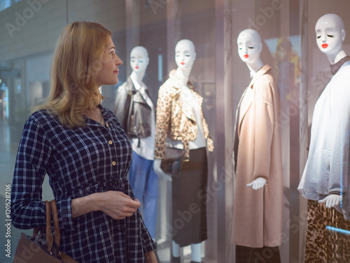 Attractive girl in a shopping center in front of a showcase