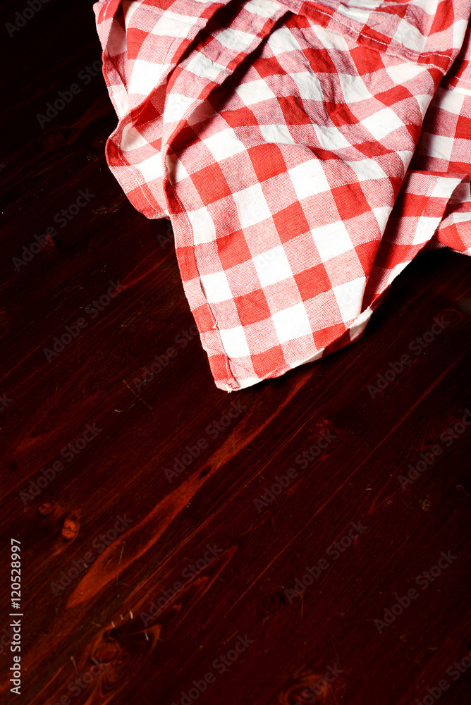 Obraz premium top view of checkered napkin on wooden table
