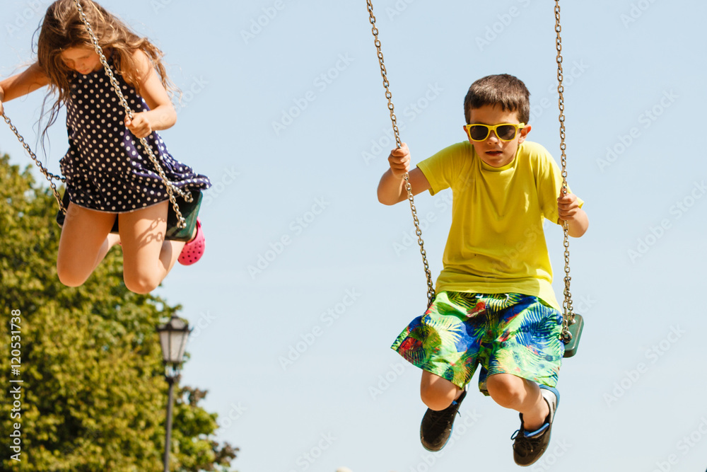 Two children having fun on swingset.