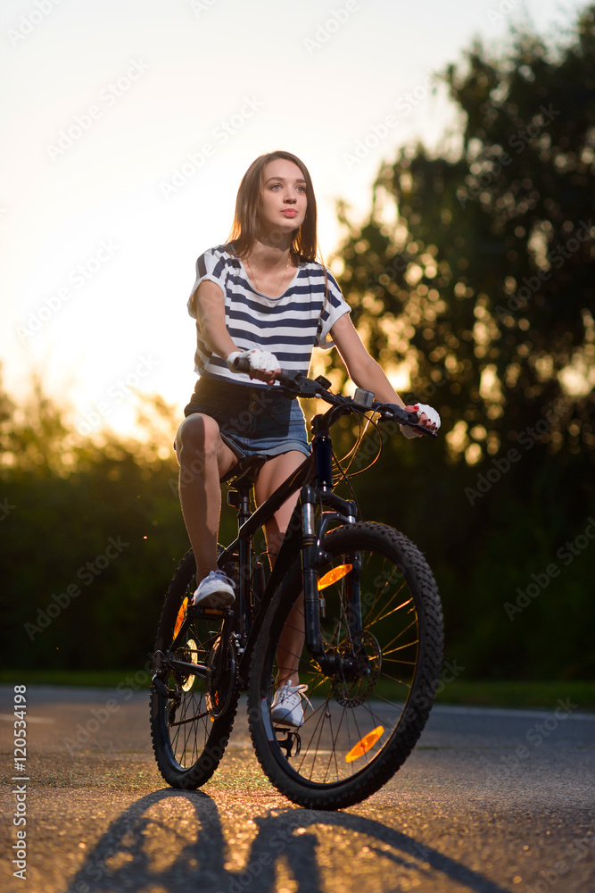 Fototapeta premium girl on a bicycle at sunset