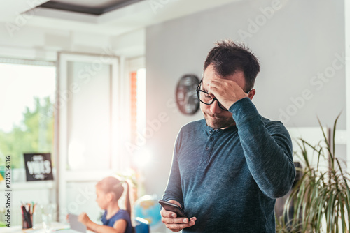 Worried father looking at smart phone photo