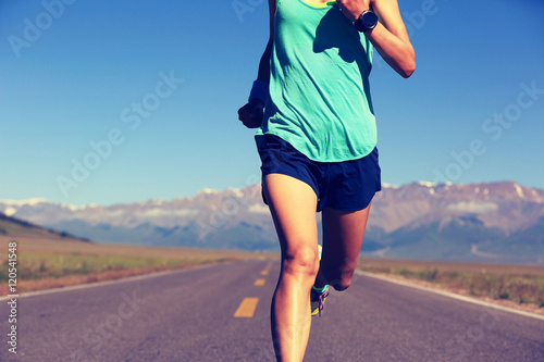 healthy young fitness woman trail runner running on road