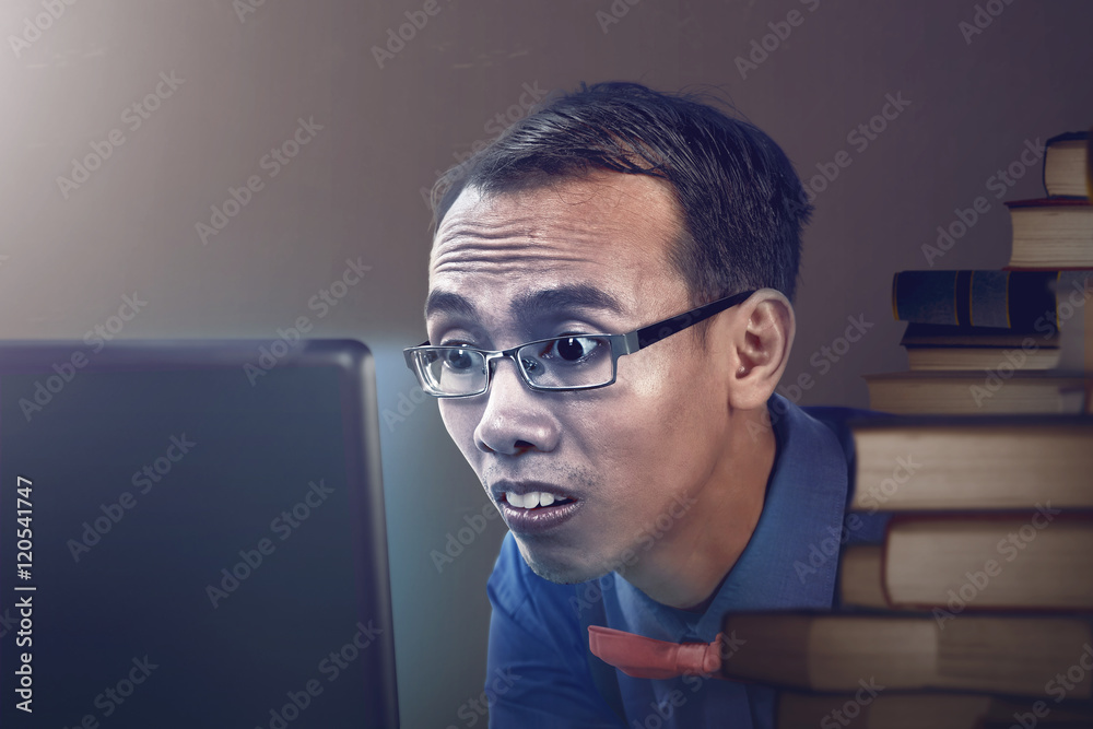 Nerdy man studying with laptop Nerdy man studying with laptop