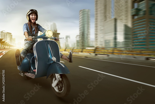 Asian woman riding scooter and wearing helmet photo