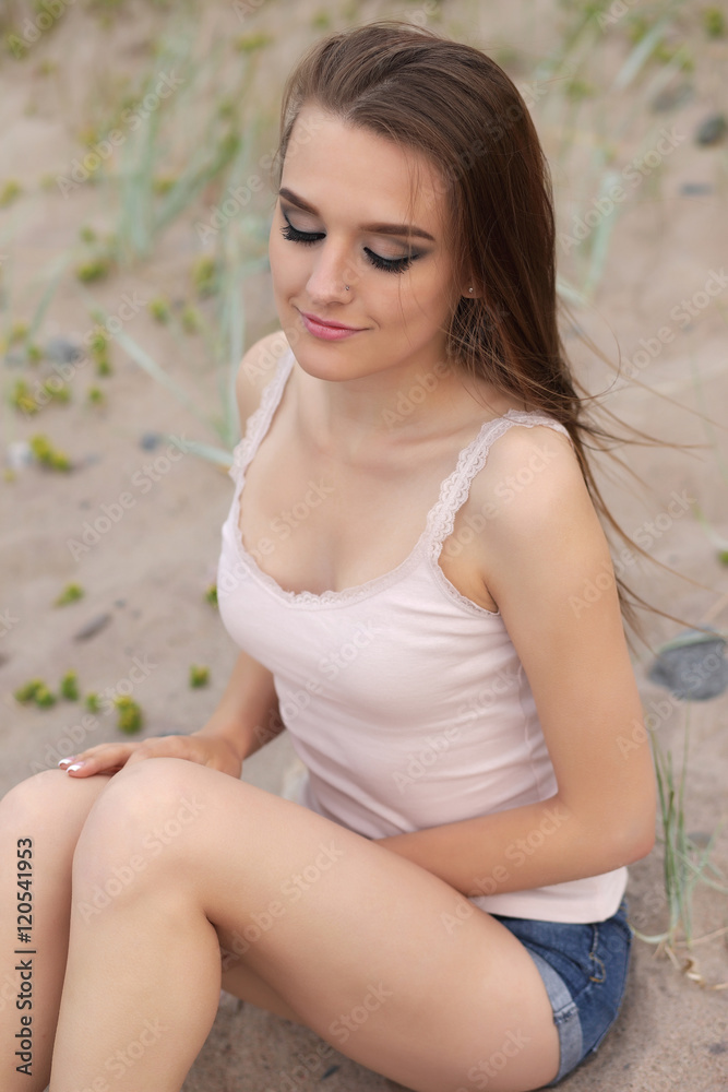Young beautiful girl posing on the beach Young beautiful girl posing on the beach