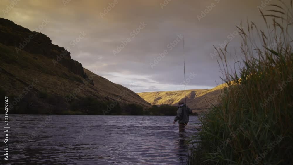 Man fly fishing in beautiful river at sunrise Man fly fishing in beautiful river at sunrise