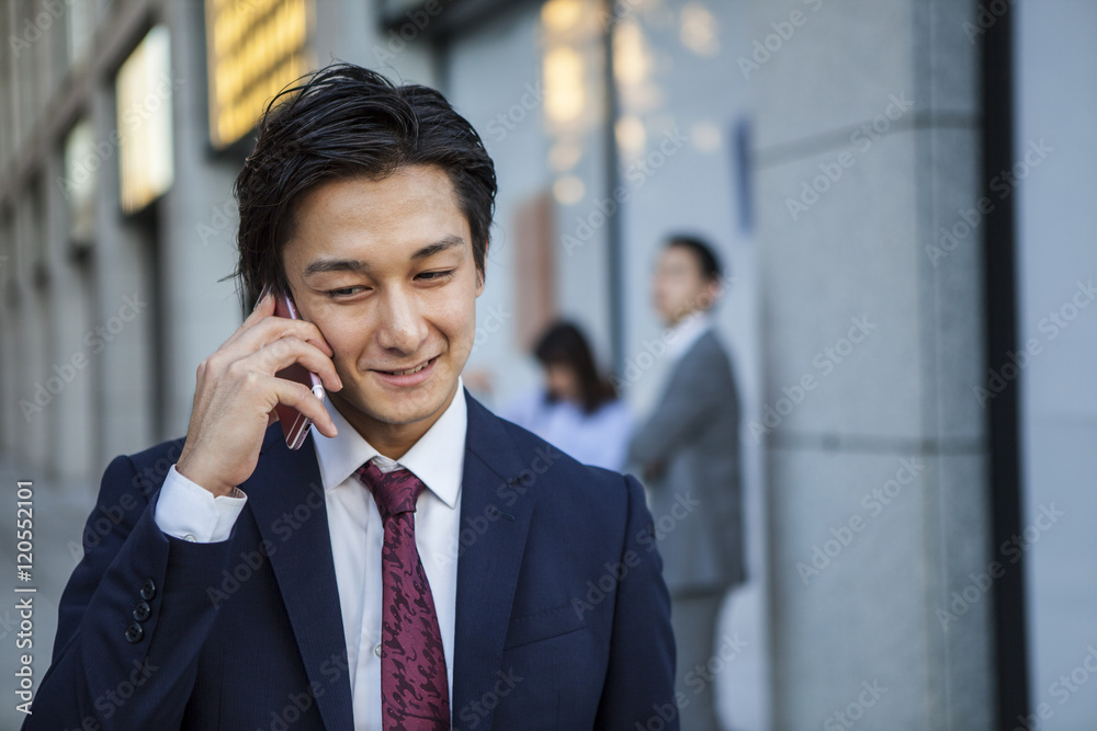 Businessman is talking on the mobile phone in the office district Businessman is talking on the mobile phone in the office district