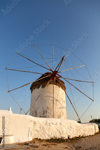Windmill in front of a blue sky in Mykonos island, Greece at sun