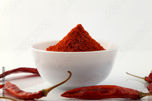 red chillies with red chilly powder on white background photo