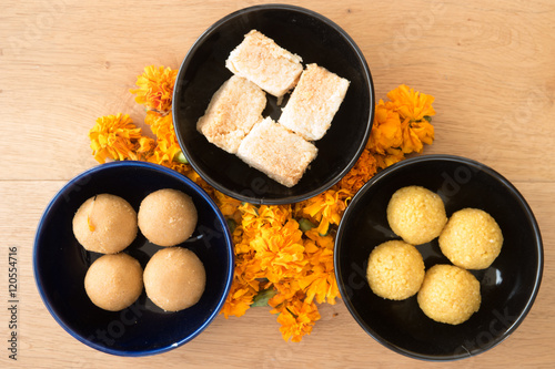 Diwali prayer celebration preparation with Indian sweets and marigold flowers photo