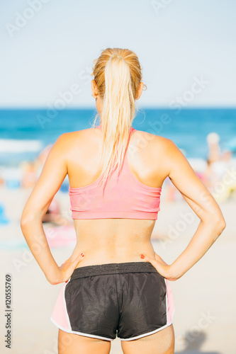 Young blonde woman in sportswear on beach © click_and_photo