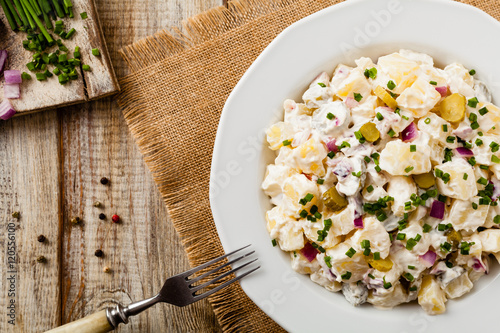 Traditional German potato salad with cucumber, onion and mayonna photo